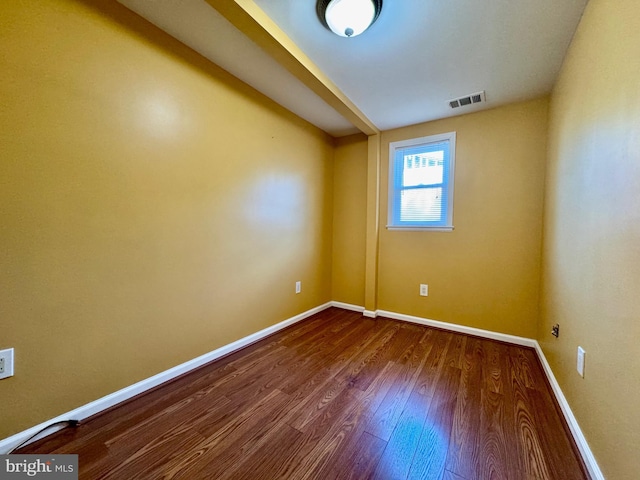 unfurnished room with dark wood finished floors and baseboards