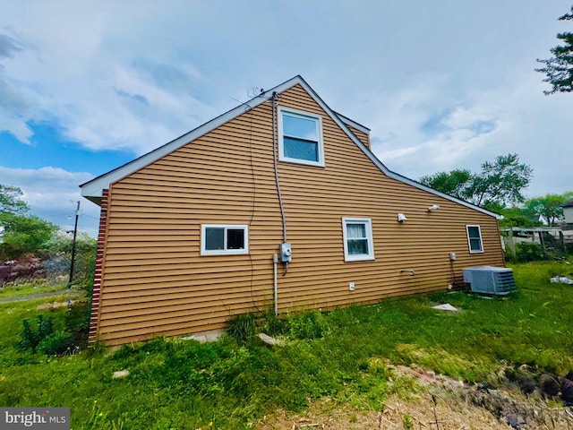 view of side of property with central air condition unit and a chimney