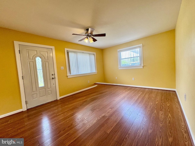 foyer with ceiling fan, wood finished floors, and baseboards