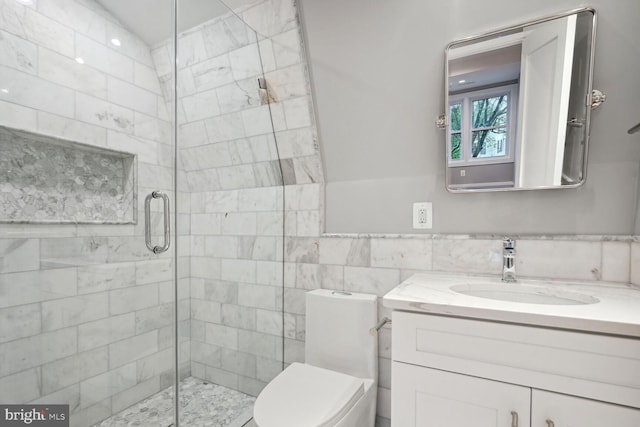 bathroom featuring vanity, a shower with shower door, tile walls, and toilet