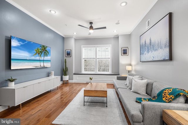 living room featuring crown molding, ceiling fan, and hardwood / wood-style floors