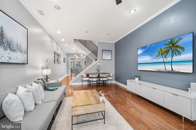 living room featuring crown molding and light wood-type flooring