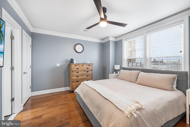 bedroom featuring crown molding, dark wood-type flooring, and ceiling fan