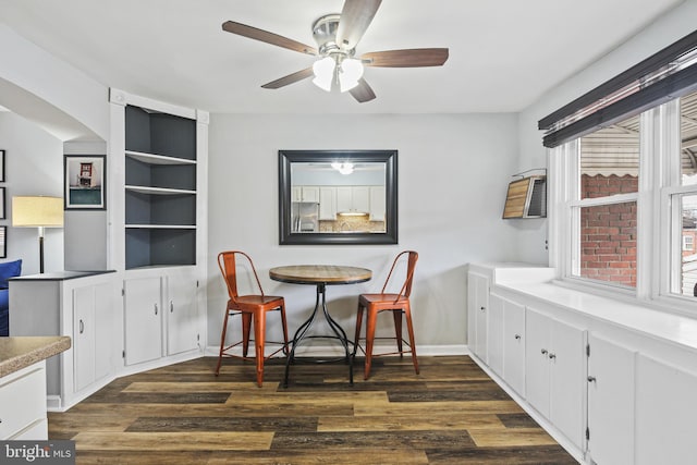 dining area with dark wood-style floors, ceiling fan, and baseboards