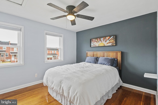 bedroom featuring wood finished floors, a ceiling fan, and baseboards