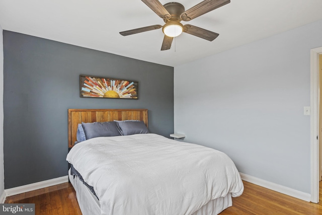 bedroom featuring wood finished floors, a ceiling fan, and baseboards