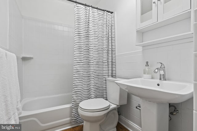 bathroom with shower / bath combination with curtain, tile walls, toilet, and wood finished floors