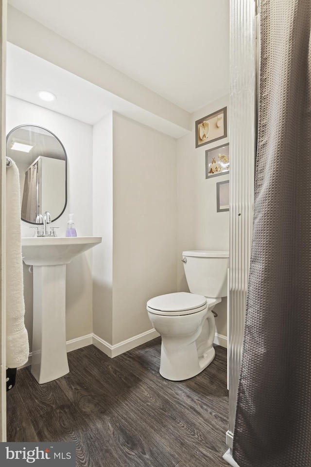 full bathroom featuring baseboards, toilet, and wood finished floors