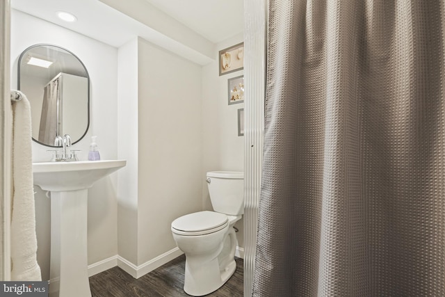 bathroom featuring toilet, baseboards, and wood finished floors