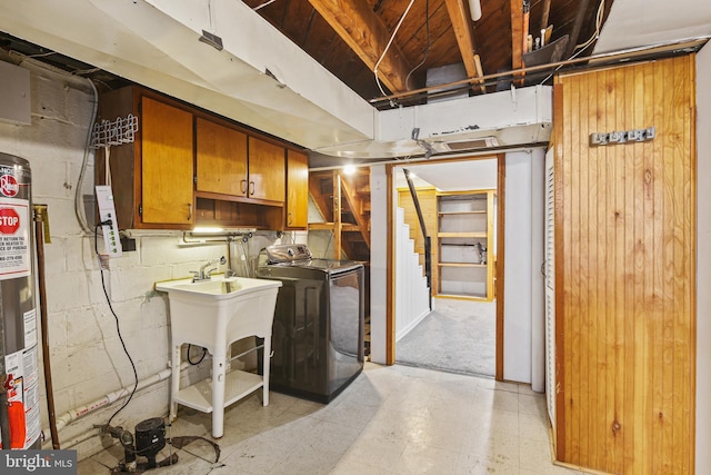 interior space with concrete block wall, water heater, stairway, light floors, and washer / dryer