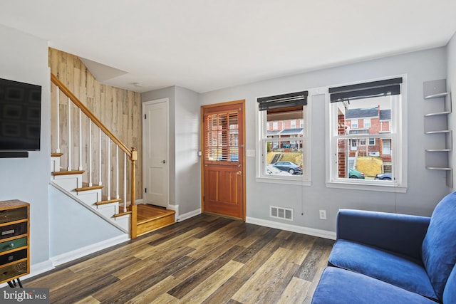 entrance foyer featuring visible vents, stairway, baseboards, and wood finished floors