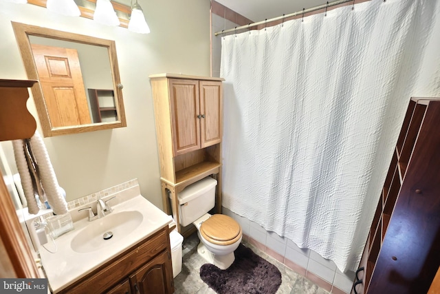 bathroom with a shower with curtain, vanity, tile patterned floors, and toilet