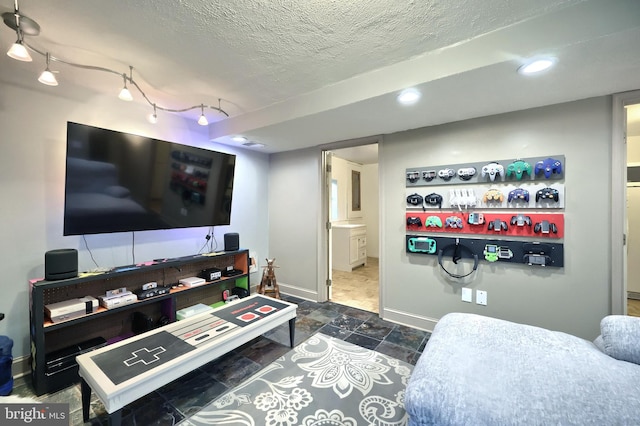 interior space with rail lighting and a textured ceiling