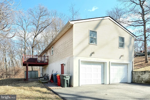 view of side of home featuring a wooden deck and a garage