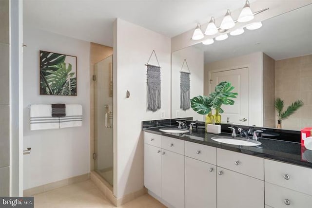 bathroom with a sink, a shower stall, and double vanity