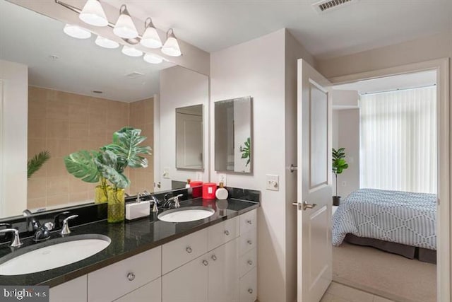 bathroom featuring double vanity, visible vents, a sink, and ensuite bathroom