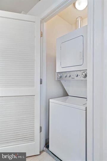 washroom featuring stacked washer and dryer and laundry area