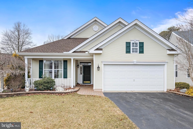 front facade with a garage, a front lawn, and covered porch