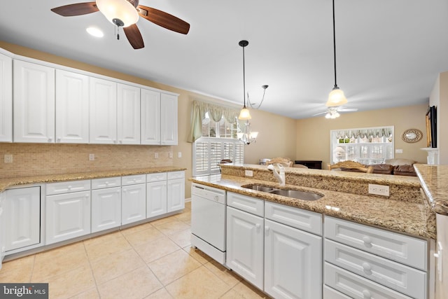 kitchen featuring pendant lighting, sink, white dishwasher, a healthy amount of sunlight, and white cabinets