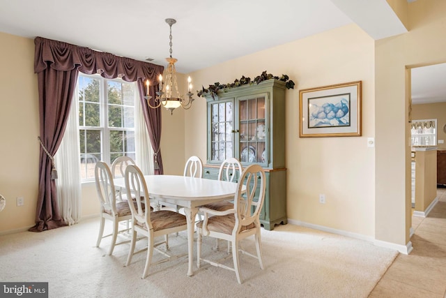 carpeted dining area with a chandelier