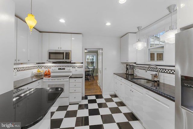 kitchen featuring sink, backsplash, pendant lighting, stainless steel appliances, and white cabinets