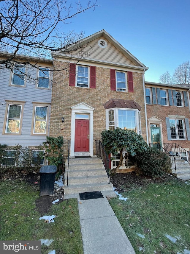 view of property with a front lawn and brick siding