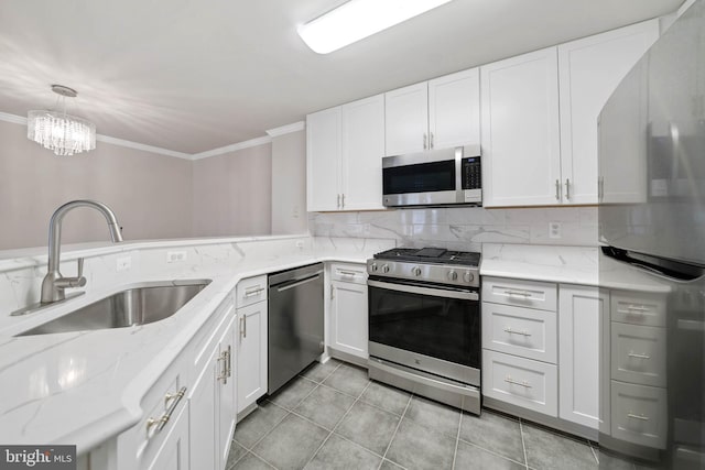 kitchen featuring sink, crown molding, appliances with stainless steel finishes, hanging light fixtures, and white cabinets