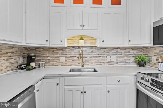 kitchen featuring white cabinets, stainless steel appliances, tasteful backsplash, and sink