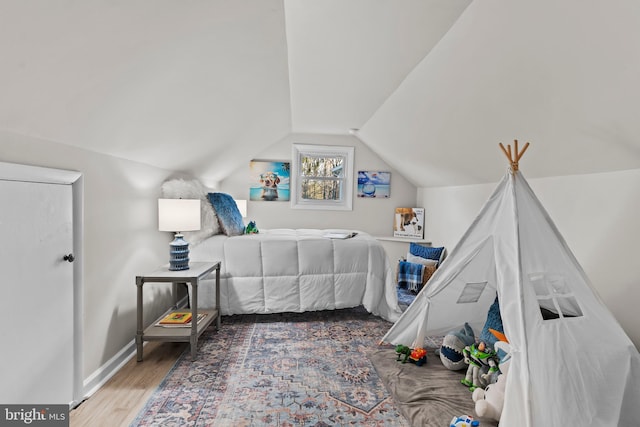 bedroom with hardwood / wood-style floors and vaulted ceiling