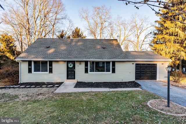 ranch-style house featuring a front lawn and a garage