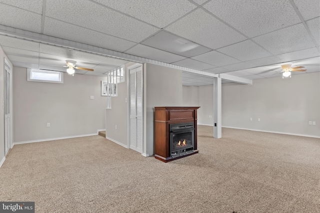 unfurnished living room featuring ceiling fan, carpet flooring, and a drop ceiling