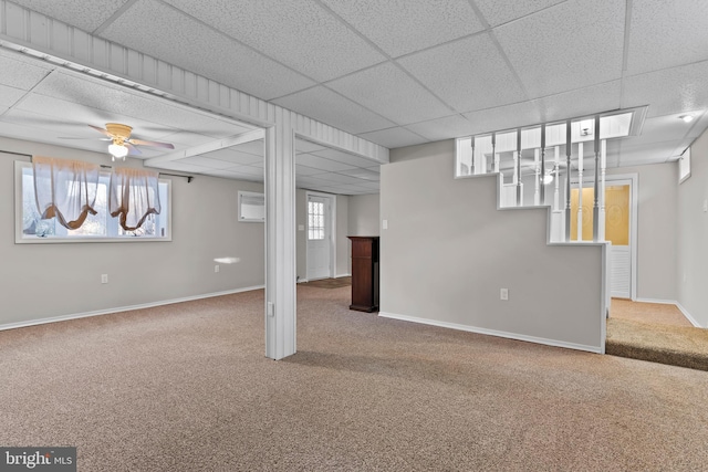 basement featuring a drop ceiling, ceiling fan, and carpet flooring