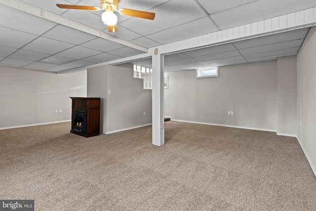 basement with ceiling fan, carpet flooring, and a paneled ceiling