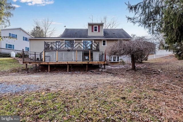 rear view of property featuring a wooden deck