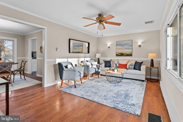 living room with ceiling fan, crown molding, dark hardwood / wood-style floors, and a baseboard radiator