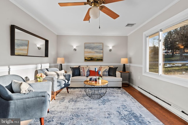 living room with hardwood / wood-style floors, baseboard heating, ceiling fan, and ornamental molding