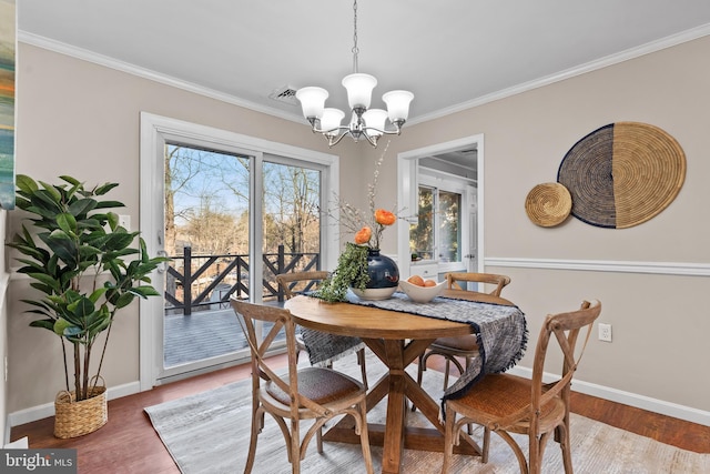 dining room featuring an inviting chandelier, hardwood / wood-style flooring, and ornamental molding