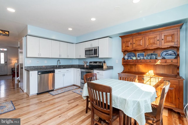 kitchen featuring white cabinets, light wood-style flooring, and stainless steel appliances