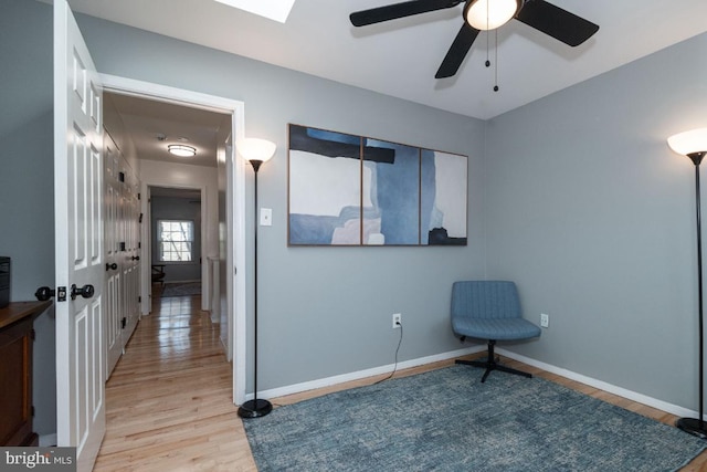 unfurnished room featuring light wood-type flooring, ceiling fan, and baseboards