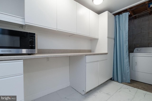 laundry room featuring laundry area, marble finish floor, washer / dryer, and concrete block wall