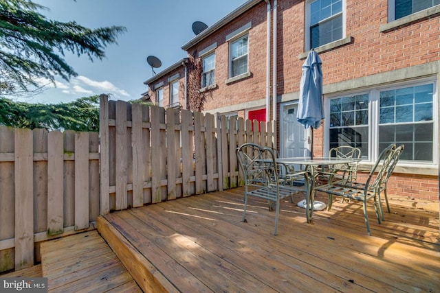 deck featuring outdoor dining area and fence