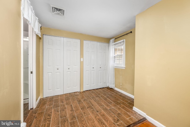 unfurnished bedroom featuring two closets