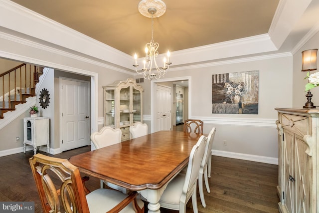 dining area with dark hardwood / wood-style flooring, a tray ceiling, and an inviting chandelier