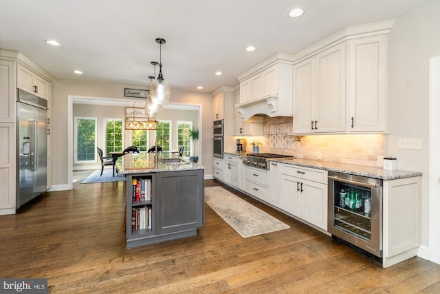 kitchen featuring wine cooler, decorative light fixtures, stainless steel appliances, and white cabinets