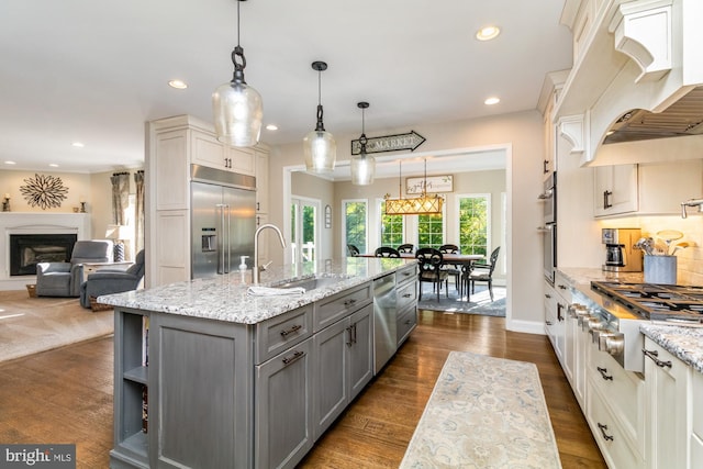 kitchen featuring gray cabinets, premium range hood, appliances with stainless steel finishes, pendant lighting, and sink