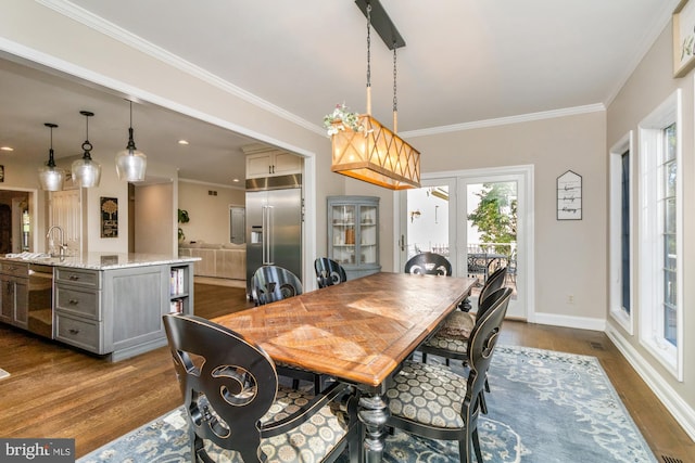 dining room with crown molding, dark hardwood / wood-style flooring, and sink