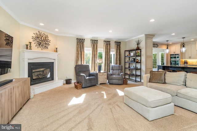 carpeted living room featuring ornamental molding and plenty of natural light