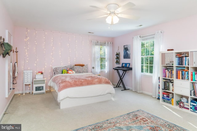 carpeted bedroom featuring ceiling fan and multiple windows