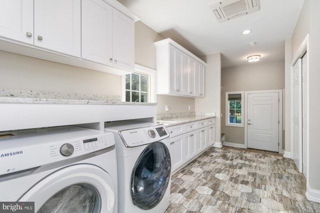 clothes washing area with cabinets and independent washer and dryer