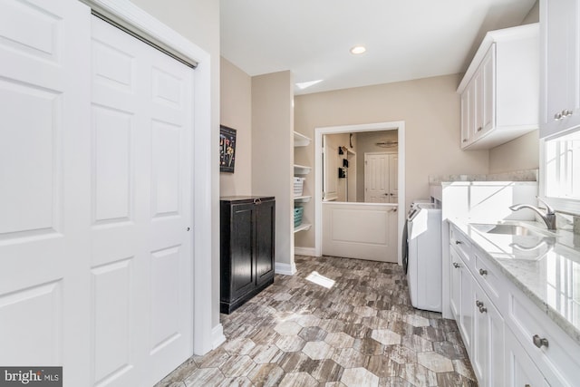 washroom with cabinets, washer / dryer, and sink